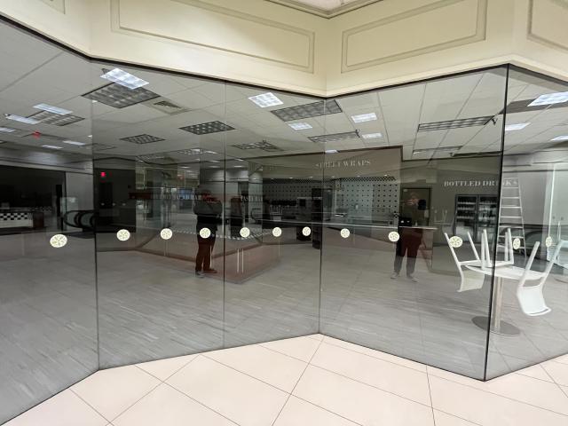 A dark shuttered shop looking through glass into it
